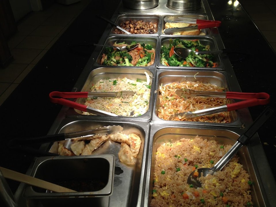 Buffet selection of sushi, crab, and orange chicken.